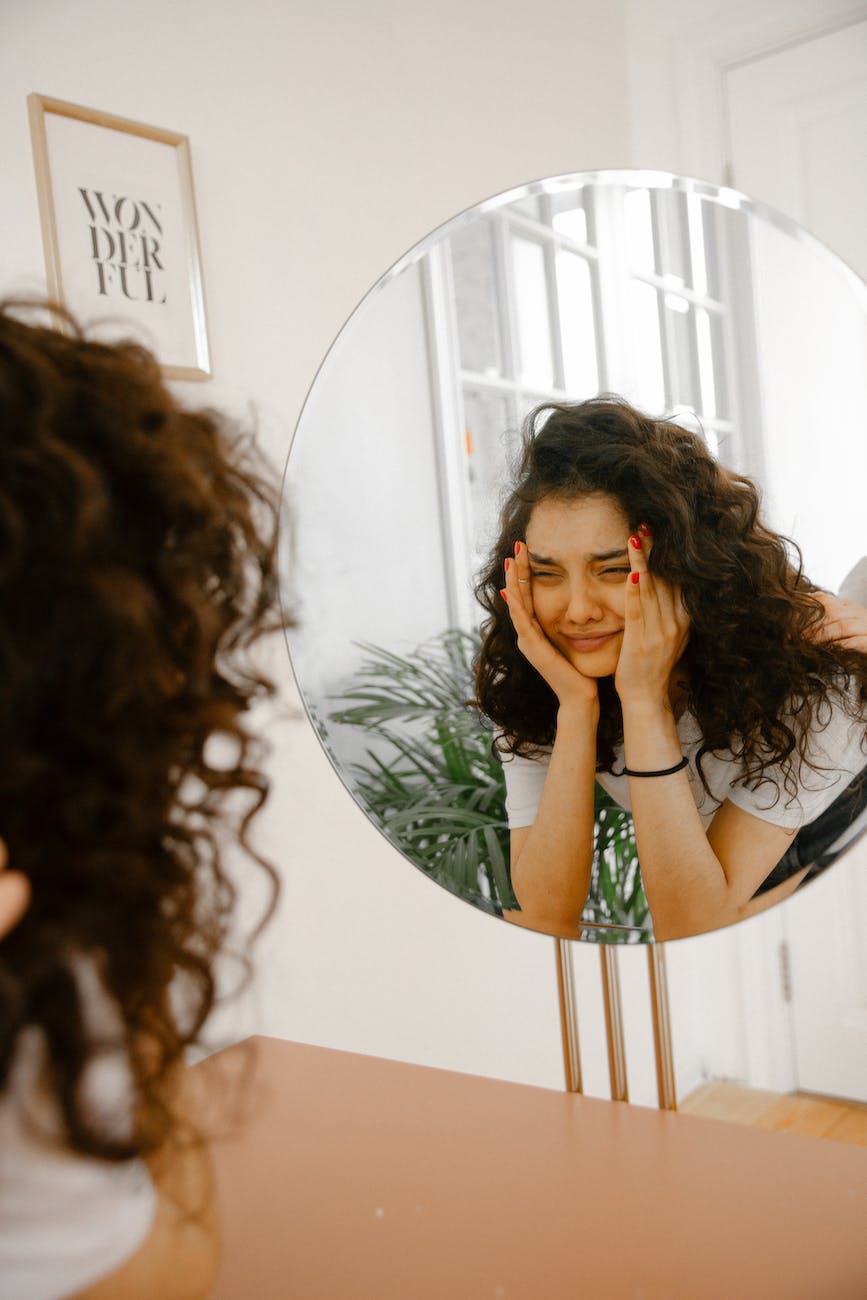 upset woman looking in mirror